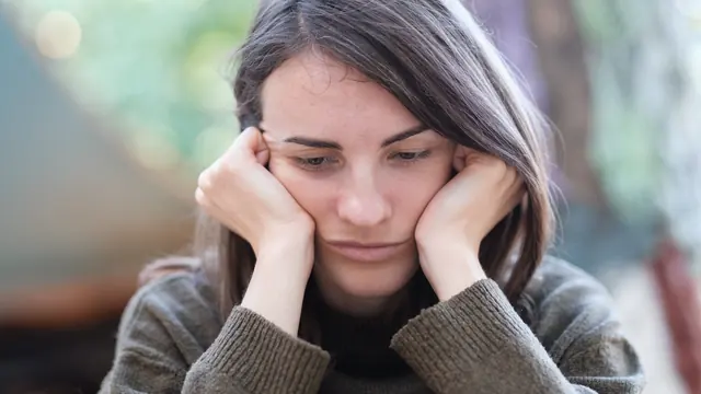A person resting their head in their hands