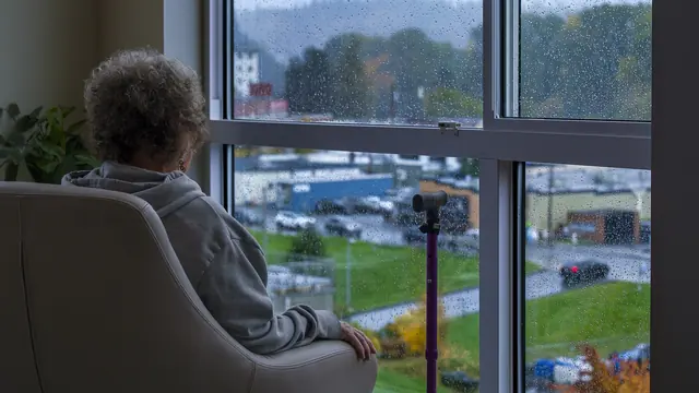 A person sitting by a window in a quiet room
