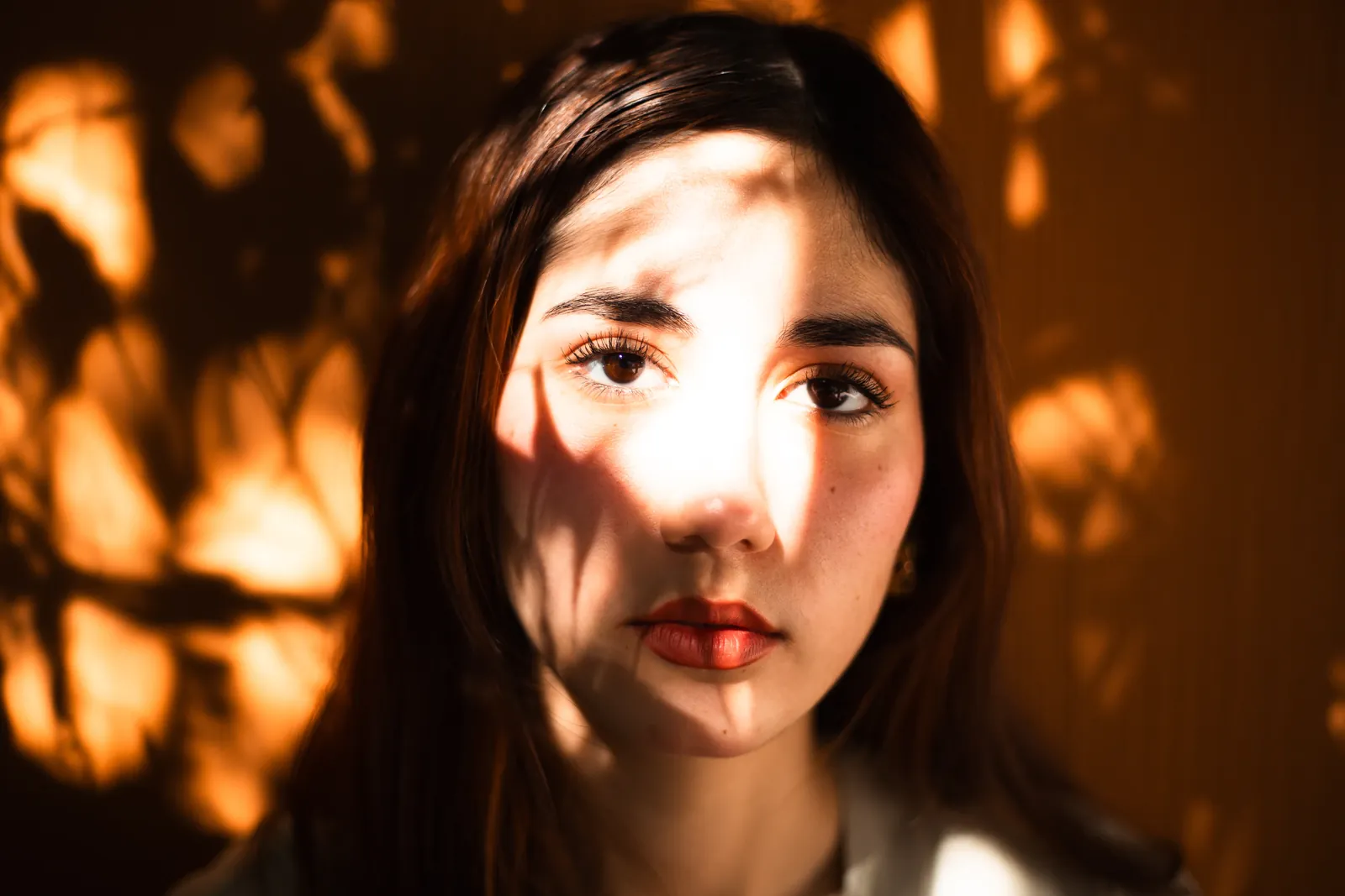 Woman with sunlight and leaf shadows on face
