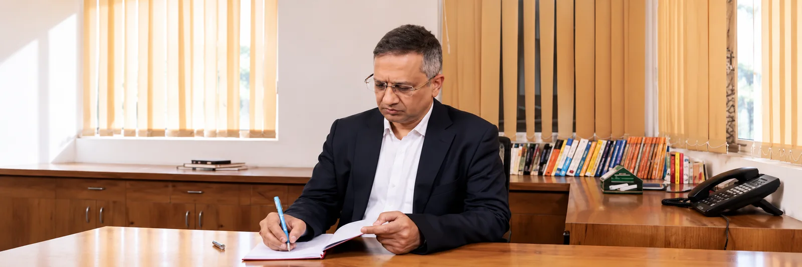Dr. Gorav Gupta writing at his desk in his office